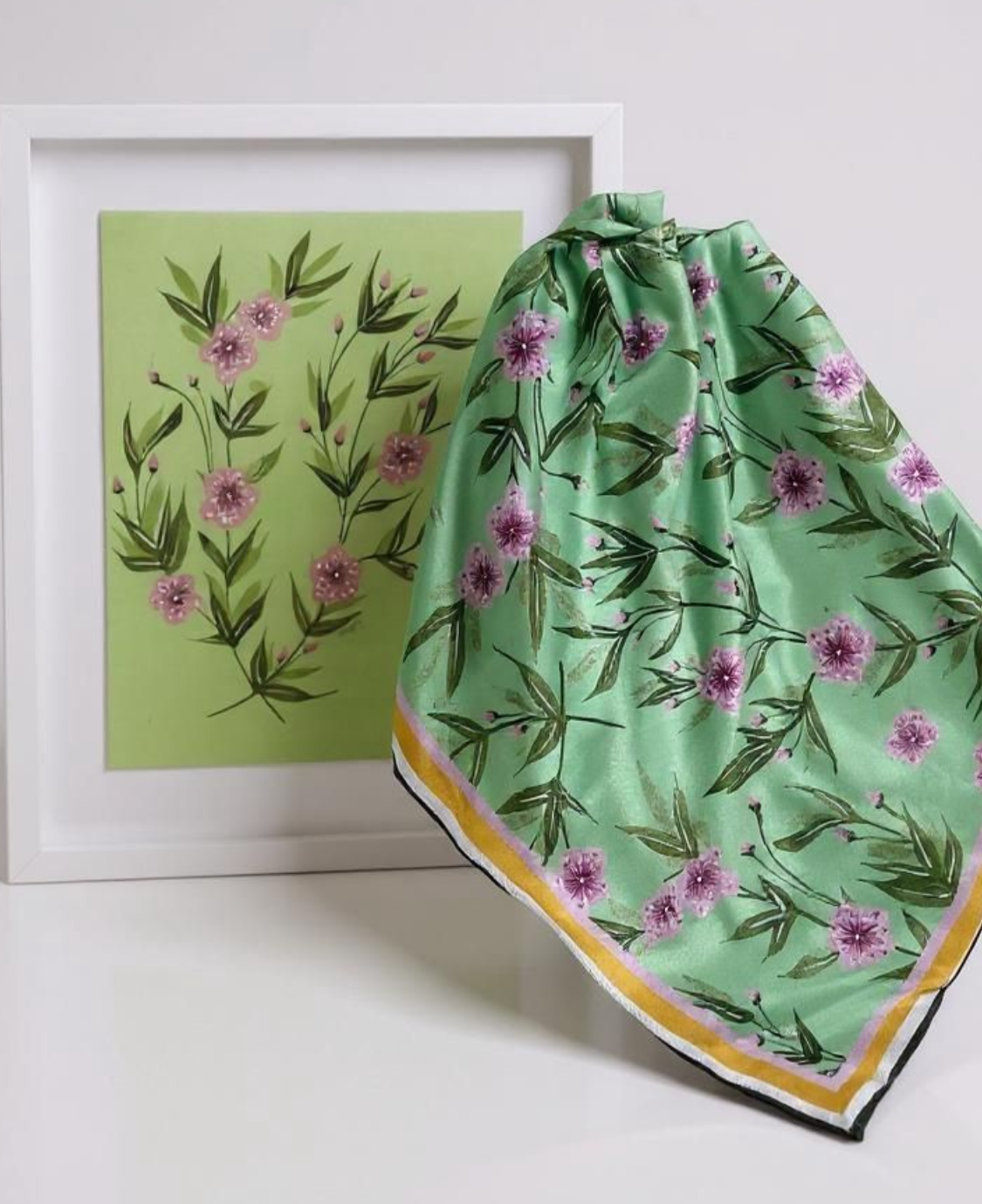 Green floral patterned fabric with a framed artwork in the background